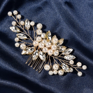 Detailed shot of bridal hair comb with pearls and marquise crystals on blue silk