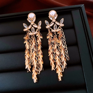 Detailed close-up of 18K gold-plated flower tassel earrings with pearls and crystals