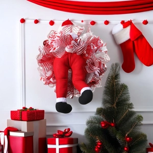 Christmas wreath with Santa Claus legs and hat decoration on a festive background