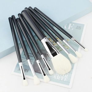 Detail of 8 professional makeup brushes with black handles and white soft bristles