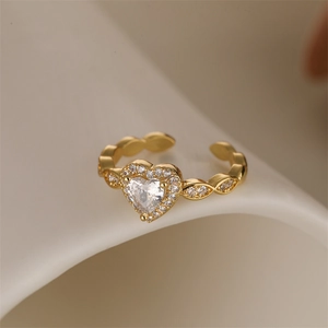 Macro shot of gold heart ring with micro-pave cubic zirconia on a cream background