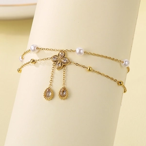 Detailed close-up of golden clover anklet with white pearls and sparkling crystal drops