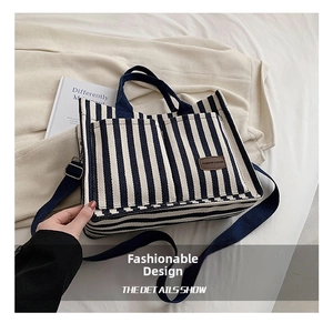 Detail of striped canvas tote bag showing dual front pockets and durable fabric handles