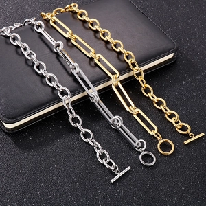 Gold and silver stainless steel chunky link bracelets with OT toggle clasps on a dark surface