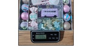 Detailed view of colorful Christmas ornaments set in packaging on a digital scale