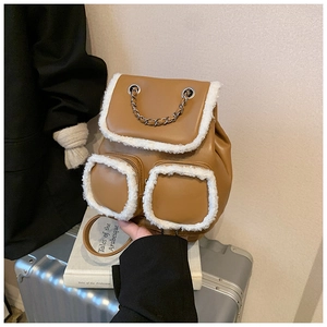 Close-up of brown faux leather backpack with white faux fur trim and metal chain detail