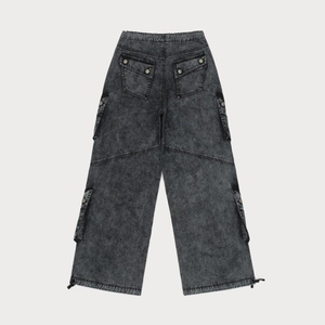 Macro view of snow-washed dark grey cargo pants featuring large utility rear flap pockets