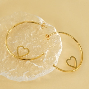 Orecchini a cerchio in acciaio inossidabile 18K con cuori su sfondo di raso dorato