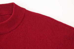 Detail of red knitted cardigan collar with fine stitching and soft fiber texture