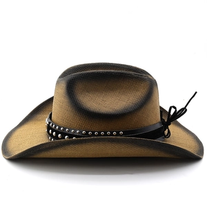 Detail of western straw cowboy hat featuring metal studs and dark gradient brim texture