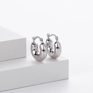 Macro shot of silver teardrop hoop earrings showing glossy polished metallic finish