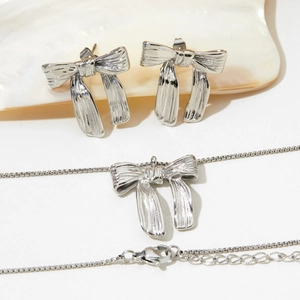 Elegant bow tie pendant necklace and stud earrings set in silver stainless steel finish