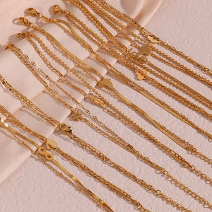 Close-up of golden multi-layer chains featuring star, heart, and clover pendants on satin