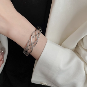 Close-up of a silver twisted spiral open cuff bracelet in minimalist hollow metal design