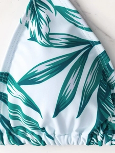 Detail of tropical leaf print on high-waisted bikini top with fine stitching