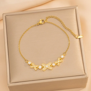 Luxury gold stainless steel bracelet featuring zircon X-pendants and adjustable chain