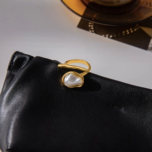 Detailed macro of 18K gold-plated stainless steel ring with Baroque pearl on black leather
