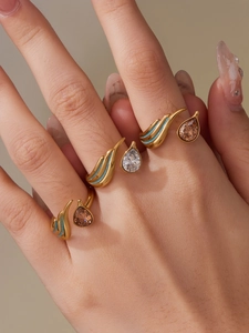 Macro shot of gold teardrop rings with turquoise enamel and champagne crystals
