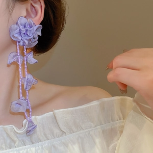 Detail of purple chiffon flower earrings with handcrafted bead tassels on model