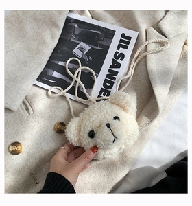 Close-up of white plush bear crossbody bag with soft teddy fleece texture and cord strap