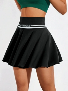 Dettaglio gonna da tennis a pieghe nera con fascia GYMWEAR e tessuto a maglia sportiva