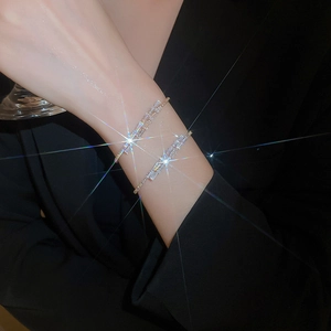 Detailed view of a layered silver bracelet with sparkling square zircon stones on wrist