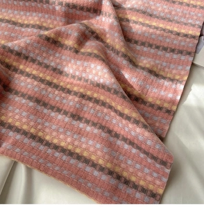 Close-up of thick rainbow plaid scarf fabric in soft pink and yellow fuzzy wool texture