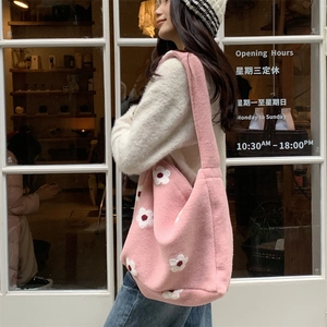 Detailed view of pink plush tote bag featuring delicate white flower embroidery details
