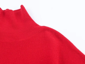 Dettaglio maglione rosso a collo alto con trama a coste sottili e linea delle spalle morbida
