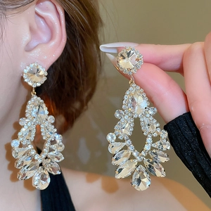 Macro view of crystal teardrop tassel earrings with sparkling rhinestones and gold base