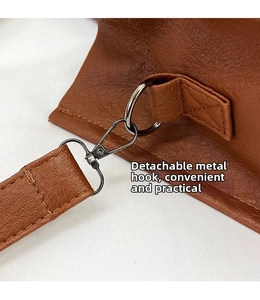 Close-up of gunmetal lobster clasp and D-ring on dark brown pebble leather tote bag