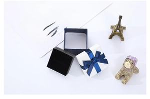 Navy blue jewelry gift box with a silk bow and black sponge lining for rings