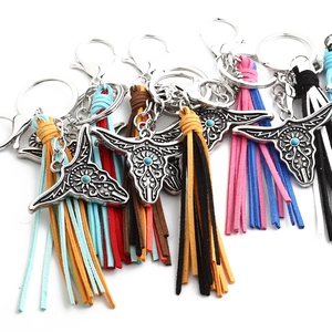 Detail of silver bull head keychain with turquoise stone and colorful suede tassels