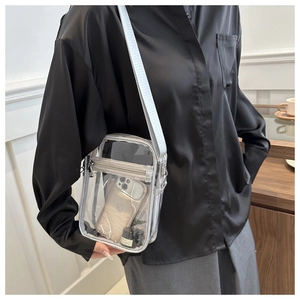 Detail of transparent PVC crossbody bag showing internal capacity with a smartphone
