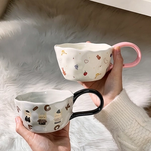 Close-up of cute ceramic bear mugs with strawberry and rabbit patterns and colorful handles
