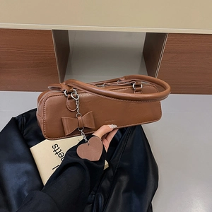Vintage brown leather underarm bag for women with bow detail and heart charm
