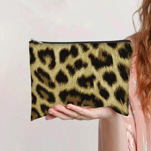 Detail of a leopard print canvas pouch featuring a black top zipper for makeup storage