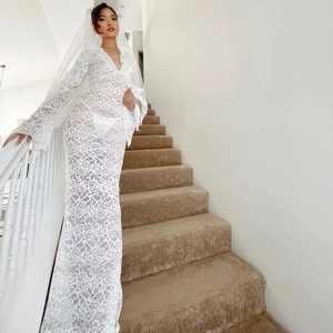 Detail view of white lace sheer maxi dress with long flare sleeves and matching veil