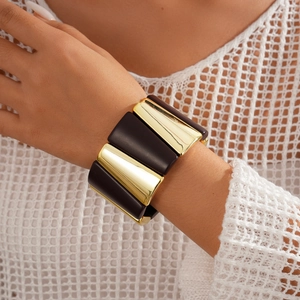 Close-up of geometric acrylic and gold metal block stretch bracelet on model wrist