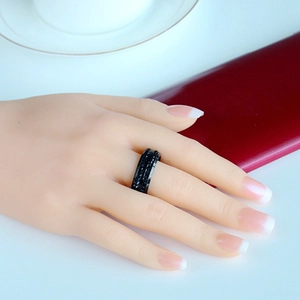 Close-up of black wide titanium steel ring with sparkling textured matte surface on model