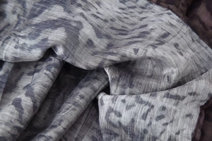Primer plano de tela ligera con estampado abstracto gris azulado y textura suave