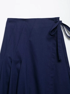 Detailed view of navy blue woven fabric with textured side ties and skirt pleats