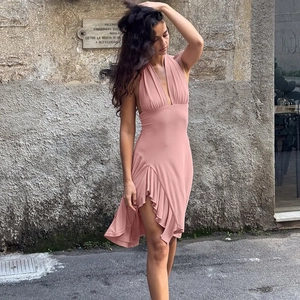Detail view of pink deep V-neck backless dress with ruffle hem and high slit design