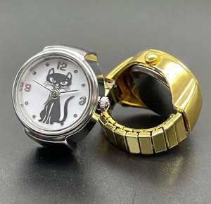 Detail of silver and gold watch rings with cat dial and stretch metal bands