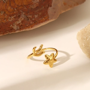 Dettaglio anello regolabile dorato con stella marina e corallo con finitura oro 18K
