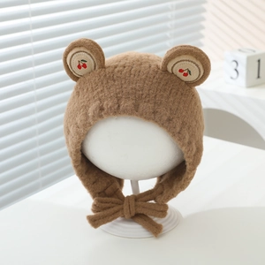 Détail du bonnet peluche marron pour bébé avec oreilles d'ours et broderie cerise
