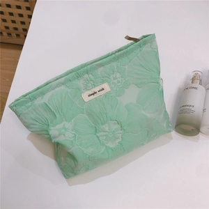 Close-up of mint green floral textured canvas makeup bag with simple wish label