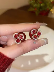 Detail of red floral pearl earrings with clear crystals and a luxury gold finish