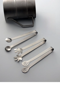 Detail of stainless steel tongs with spoon, palm, and shell shaped tips for sugar cubes