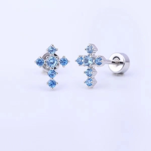 Macro detail of cross stud earrings featuring blue gemstones and secure screw back closure